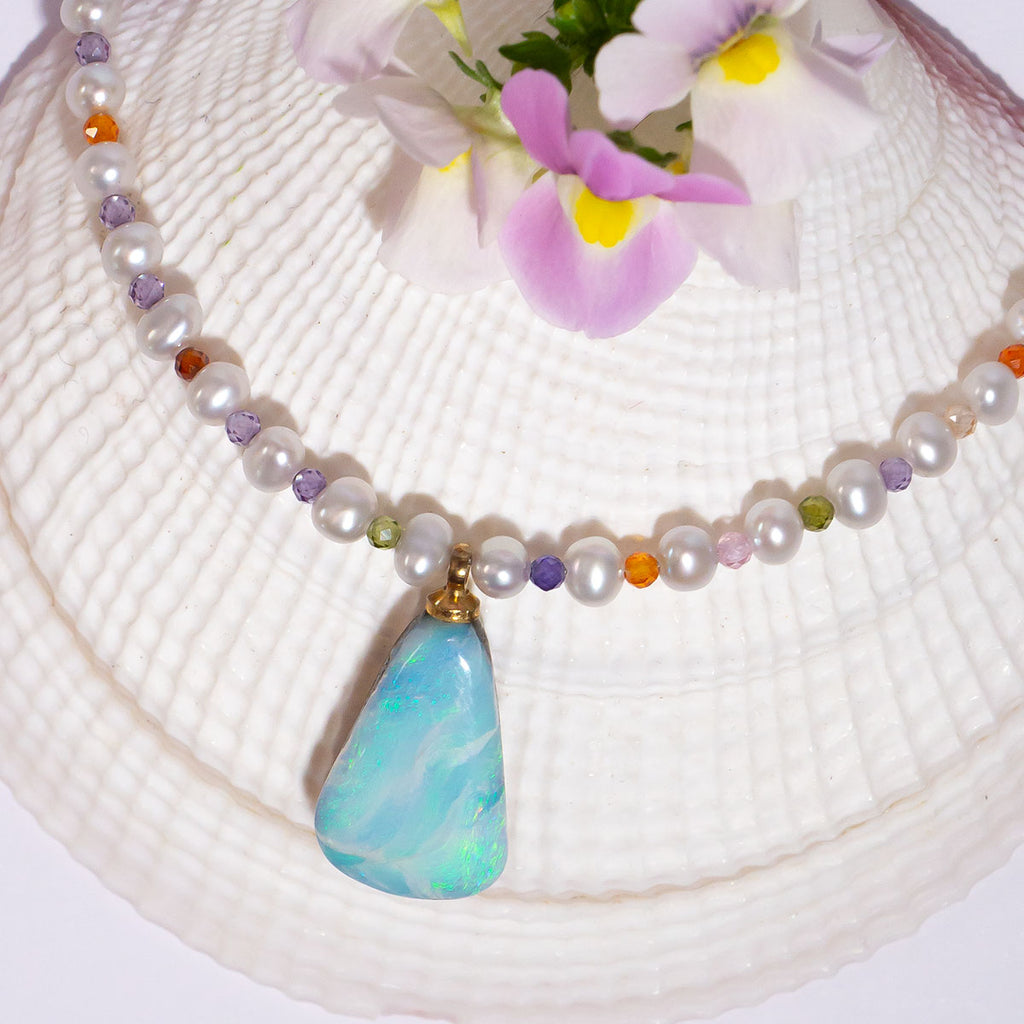 This delicate necklace hides a tiny shimmer of pastel colour between each soft white pearl. The beautiful Australian Boulder Opal pendant has lovely flashes of blue & green.