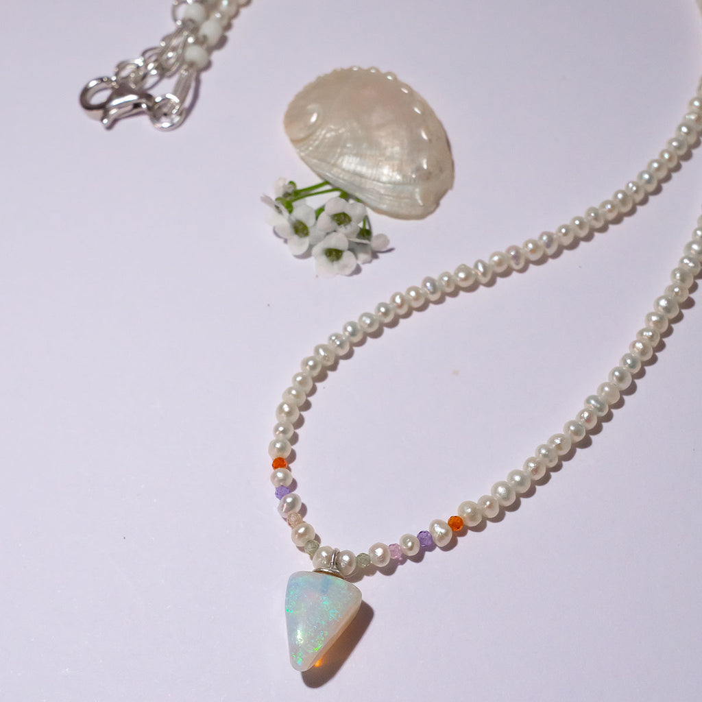 A pearl necklace with twist, we have added a tiny luminous crystal opal as the centrepiece.