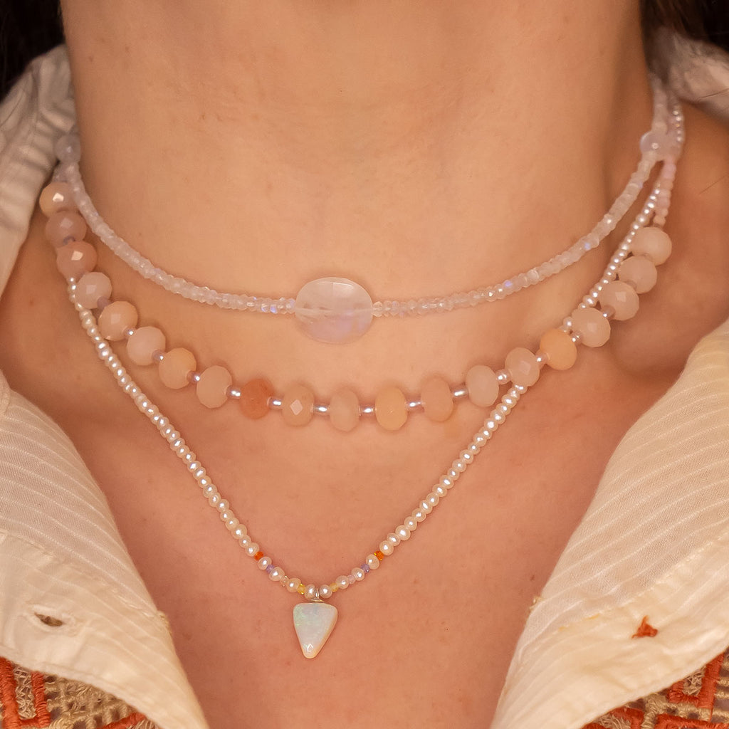 A pearl necklace with twist, we have added a tiny luminous crystal opal as the centrepiece.