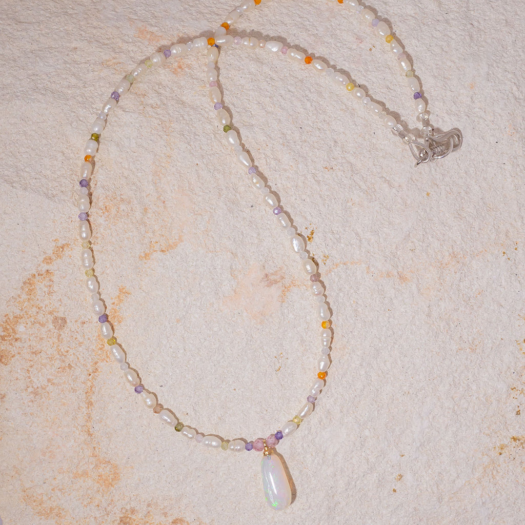 This delicate pearl & opal necklace features beautiful fresh water pearls and a magical crystal opal pendant that shimmers with sparkling green colour play.