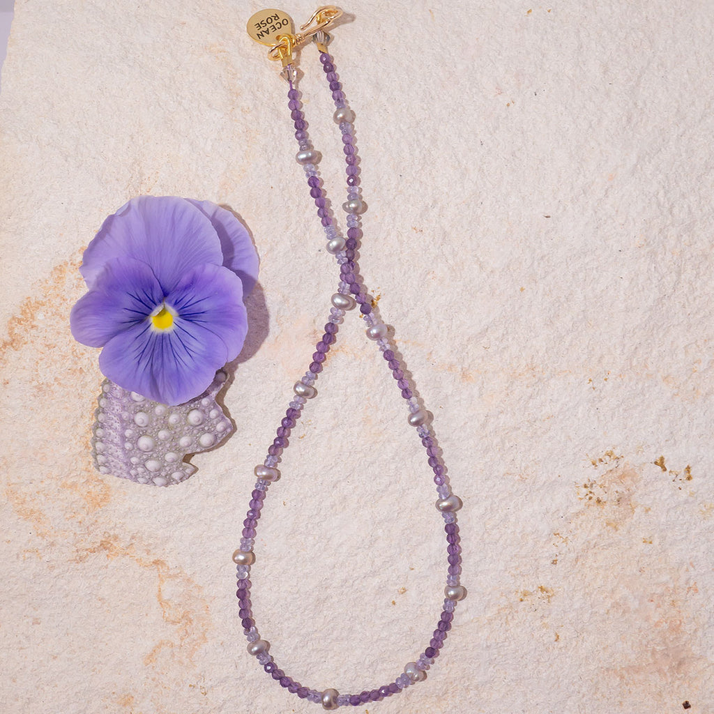 The prettiest purple necklace around. This delicate piece features soft shades of lilac & lavender and is elevated by beautiful shimmer soft grey pearls.