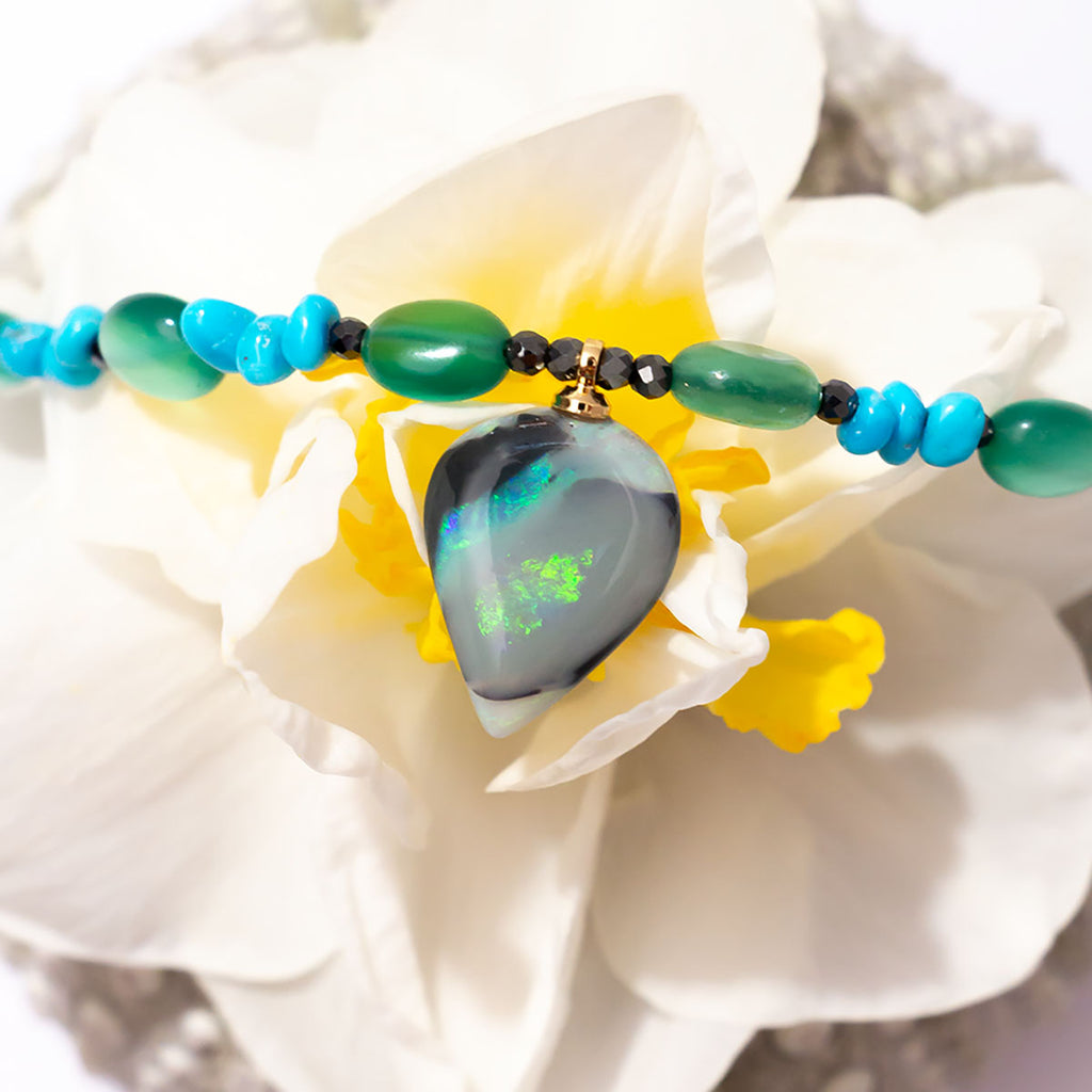 With gorgeous bubbles of green onyx, intense sky-blue Sleeping Beauty turquoise and a luminous black opal with shimmering streaks of green and aqua colour play this is a truly enchanting piece.