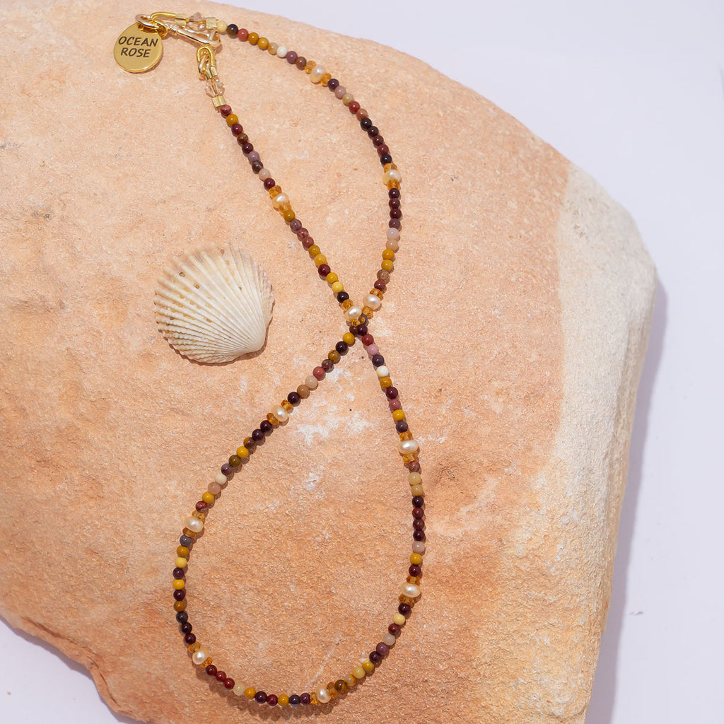 A delicate strand of earthy natural toned gemstones and shimmering deep cream pearls.