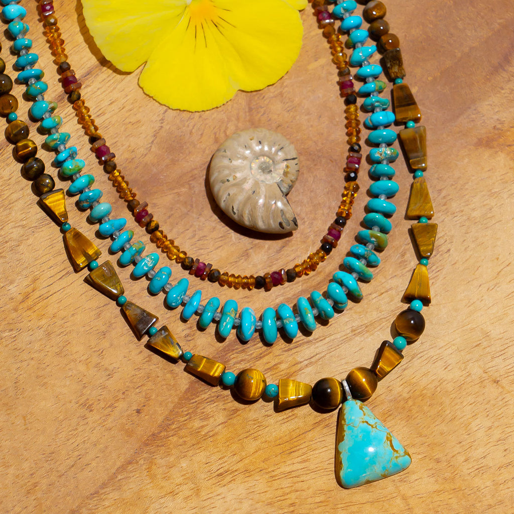 A stunning pendant of natural sleeping beauty turquoise, the rugged hand cut Tigers Eye beads lend an aura of strength and beauty. Made in Noosa Australia from old and new stock beads.